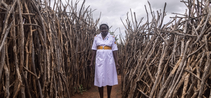 Akol Anna Grace, an assistant nursing officer of Kopoth Health Centre, poses between houses during a home visit in Kopoth, Karamoja region, Uganda, on May 25, 2022. Badru Katumba/AFP via Getty
