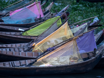 Boatmen sleep inside colorful mosquito nets on their boats on the Buriganga River in Dhaka, Bangladesh