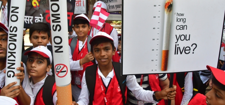 Children hold signs and giant paper cigarettes emblazoned with "No Smoking" to raise awareness of the harms caused by tobacco products on World No Tobacco Day. Mumbai, India, May 31, 2022. 