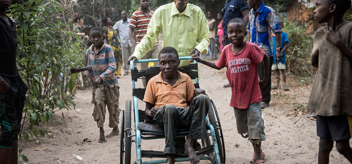 Etienne Tshiluanjim, 28, center in the wheelchair, leaving the Tomisa clinic in Kahemba with a group of children also suffering from konzo