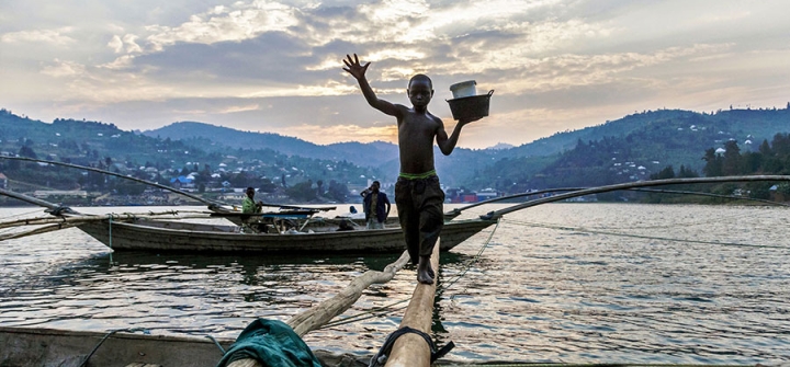 Izabayo, 13 years old, leaves the boat where he spent the night with 10 other fishermen after another fishing night at Lake Kivu on July 17, 2017. Izabayo has worked with the fishermen since he was 8 years old. Image: Natalia Jidovanu/AFP/Getty