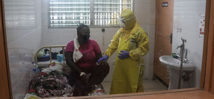 A nurse holds the hand of a patient in a COVID-19 ward of the Redemption hospital in Monrovia on July 1, 2021. Image: Emmanuel Tobey/AFP/Getty 