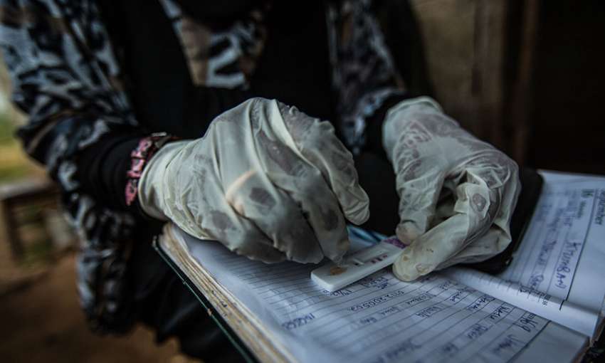 Habiba Suleiman, 29, a district malaria surveillance officer, records the results of a rapid diagnostic test for malaria at a home visit in Zanzibar, January 28, 2015. 
