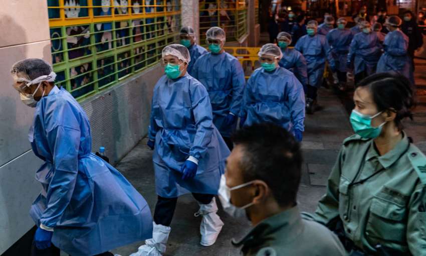 Police arrive at a public housing building as residents are evacuated to a quarantine center. Hong Kong, March 14, 2020. Image: Anthony Kwan/Getty