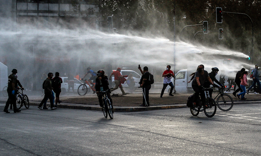 Demonstrators, wearing face masks due to COVID-19, clash with riot police during a protest against President Sebastian Pinera's government in Santiago, Chile on April 27, 2020. 