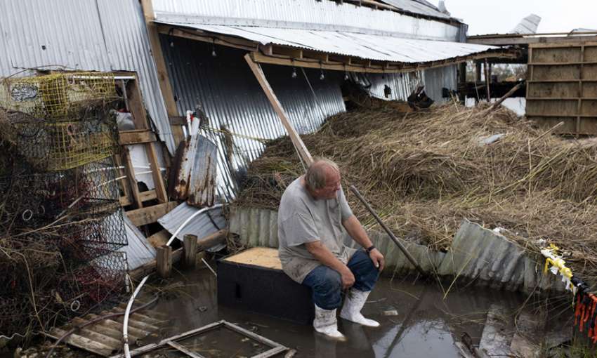 A residents watches as debris is cleared from his boat dock after Hurricane Ida. Cocodrie, Louisiana. September 1, 2021. Image: Mark Felix/Bloomberg/Getty