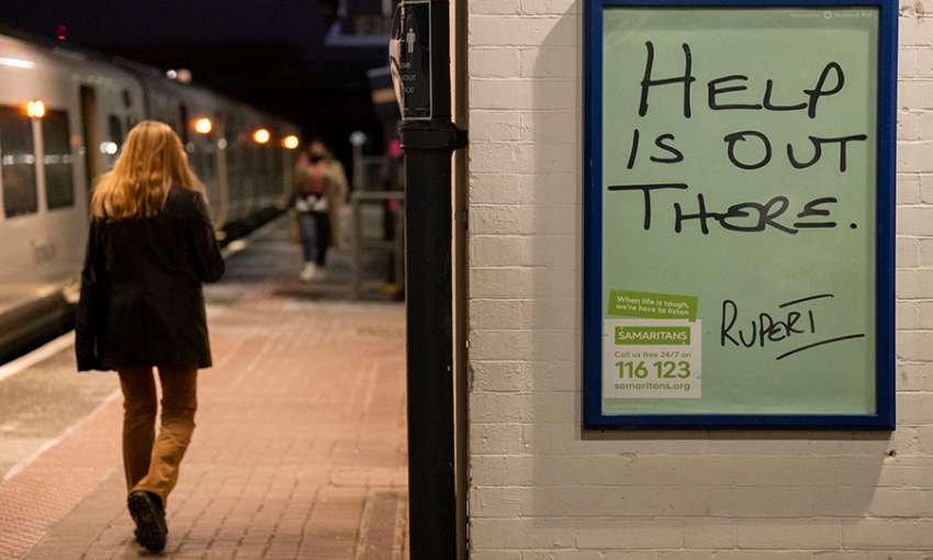 A female rail traveller walks along the platform at Loughborough Junction railway station where a Samaritan's poster urges those with mental health issues, or even thoughts of suicide, to seek help from the registered charity aimed at providing emotional support to anyone in emotional distress, struggling to cope, or at risk of suicide throughout the United Kingdom and Ireland, often through their telephone helpline, on 27th February 2021, in London, England. (Photo by Richard Baker / In Pictures via Getty 