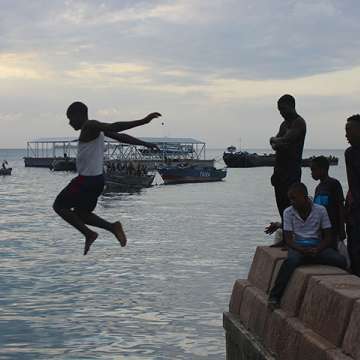 Boy diving off a pier in Zanzibar