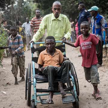 Etienne Tshiluanjim, 28, center in the wheelchair, leaving the Tomisa clinic in Kahemba with a group of children also suffering from konzo