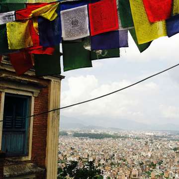 Prayer flags fluttering above Nepal. Image Courtesy of Emaline Laney.