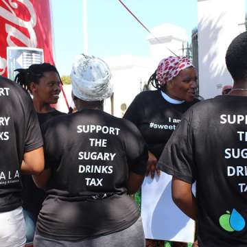 Members of the Healthy Living Alliance showing their support for the sugary drinks tax outside parliament before a parliamentary hearing.