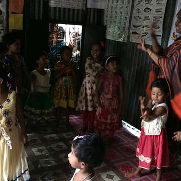 A day in an anchal: Children sing and dance to a Bangla rhyme along with their crèche mother. 