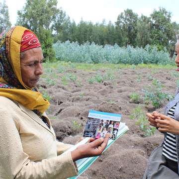 A worker with the PHE-Ethiopia Consortium, right, shares information with a schoolteacher in the rural Bale-Eco region. 
