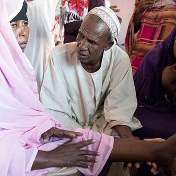A woman's left foot is checked for mycetoma by DNDi staff in Sudan; her right leg was infected with mycetoma and had to be amputated. Image by Neil Brandvold/DNDi