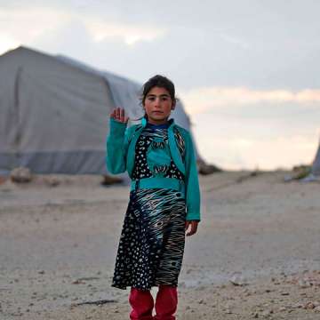 A displaced Syrian girl waves to theA Syrian girl waves to the camera at a camp in Kafr Lusin near the border with Turkey in Idlib province in northwestern Syria on Feb. 17, 2019. Image: Aaref Wata/AFP/Getty  camera at a camp in Kafr Lusin near the border with Turkey in Idlib province in northwestern Syria on February 17, 2019. (Photo by Aaref WATAD / AFP) (Photo credit should read AAREF WATAD/AFP/Getty Images)