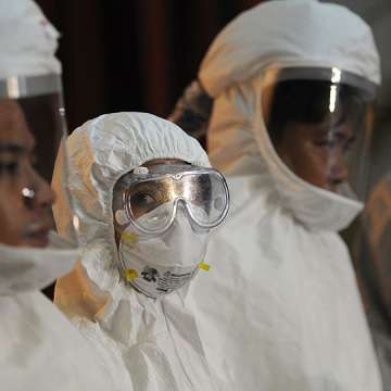 Philippine medical workers donned protective suits during a press conference by health officials on the country's preparedness against Ebola on October 21, 2014. Image: Ted Aljibe/AFP/Getty