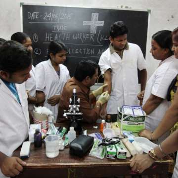 A paramedical teacher in Kolkata, India instructs students on how to draw blood. © 2015 Dipayan Bhar, Courtesy of Photoshare