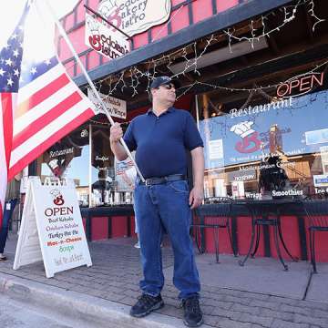 A man supports local businesses reopening in Wickenburg, Arizona on May 1, 2020.  Image: Christian Petersen/Getty