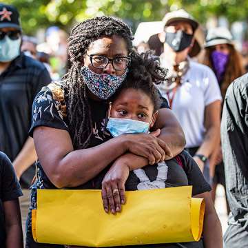 Allison Bracy of Fontana hugs her daughter Brielle Bracy, 10, while attending a rally with hundreds of demonstrators to protest the death of George Floyd during the coronavirus pandemic in Riverside, California, June 4, 2020. 