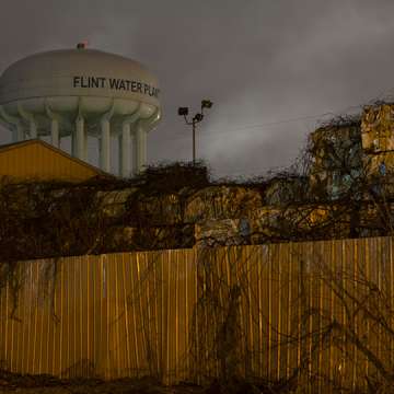The Flint City Water Plant water tower is seen from behind a metals recycling facility. December 20, 2018. Image: Brittany Greeson/The Washington Post/Getty