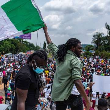 A protester waves the Nigerian flag at an anti-police brutality demonstration. Lagos, October 13, 2020. Image: Benson Ibeabuchi/AFP/Getty