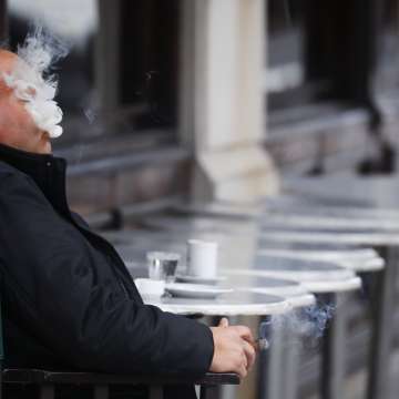 A man smokes a cigar as outside a Buenos Aires coffee store. May 22, 2021. Image: Marcos Brindicci/Getty Images