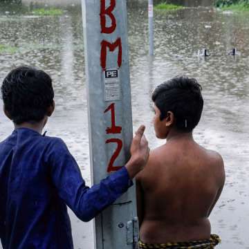 Children look out on a flooded road at the Zakhira underpass in Delhi, September 1, 2021. Image:  Naveen Sharma/SOPA Images/LightRocket via Getty