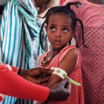A 4-year-old Ethiopian girl who fled the Tigray conflict is measured at a malnutrition center in eastern Sudan. December 2, 2020. Image: Yasuyoshi Chiba/AFP/Getty