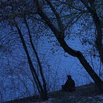 A man sits alone beside the Spree River during a lockdown in Berlin on April 16, 2021. Image: Sean Gallup/Getty Images