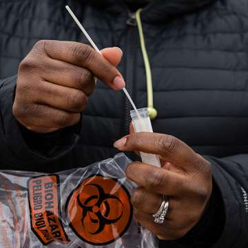 A resident inserts a nasal swab into a test tube while in line at a Covid-19 testing site run by the Centers for Disease Control (CDC), Federal Emergency Management Agency (FEMA) and eTrueNorth in Washington, D.C., U.S., on Wednesday, Jan. 5, 2022. The U.S. recorded over a million coronavirus cases on Monday, nearly doubling the previous records with hospitalizations increasing fueled by the virus rapidly spreading among the unvaccinated. Photographer: Eric Lee/Bloomberg via Getty Images