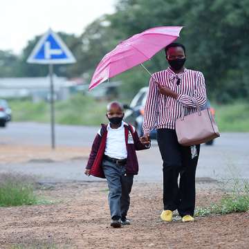 A student and his parent wearing masks walk to school as a new academic year begins in Gaborone, Botswana, Jan. 11, 2022. Image: Tshekiso Tebalo/Xinhua via Getty