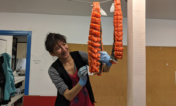Sheila Veevee prepares arctic char that was donated by a local hunter to the Pangnirtung Soup Kitchen.