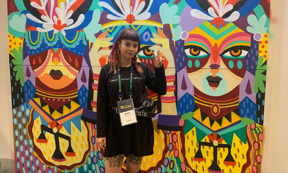 The artist Ledania, with a painting she created for Women Deliver.